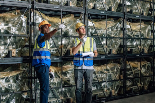 Warehouse workers standing in front of pallet racking system in fulfillment center